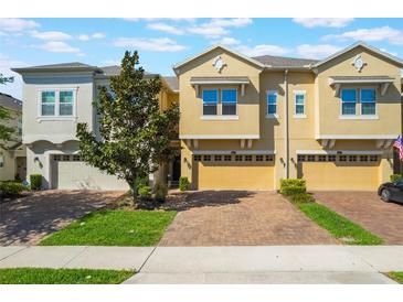 Inviting townhouse with a brick drive, manicured lawn, and an attached one car garage at 15221 Sunrise Grove Ct, Winter Garden, FL 34787