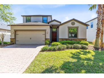 Charming two-story home with a manicured lawn, a brick driveway, and an attached two-car garage at 2224 Romanum Dr, Winter Garden, FL 34787