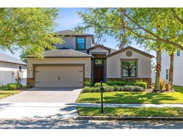 Charming two-story home featuring a brick driveway, attached garage, and well-manicured landscaping at 2224 Romanum Dr, Winter Garden, FL 34787