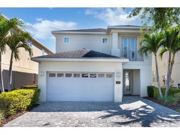 Beautiful two-story home featuring a two-car garage, well-manicured landscaping, and charming architectural details at 321 Pendant Ct, Kissimmee, FL 34747