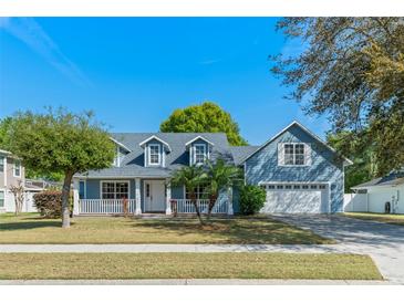 Charming two-story blue home with a well-manicured lawn and inviting front porch at 1019 Spring Landing Dr, Winter Garden, FL 34787