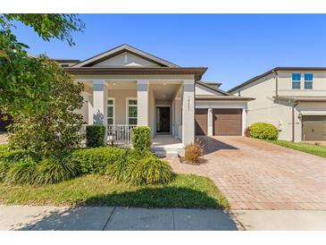 Charming single-Gathering home with a well-manicured lawn and inviting front porch at 14661 Glade Hill Park Way, Winter Garden, FL 34787