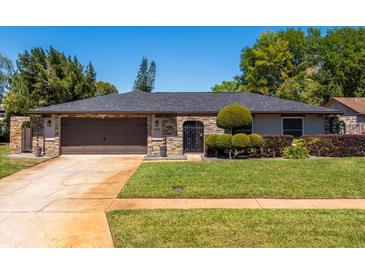 Charming home with stone accents, well-manicured lawn, and a two-car garage at 1925 Poinsetta Ln, Maitland, FL 32751