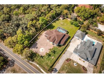 A stunning aerial view of this luxury home with a private pool, lush greenery, and spacious grounds at 1984 Windermere Rd, Windermere, FL 34786