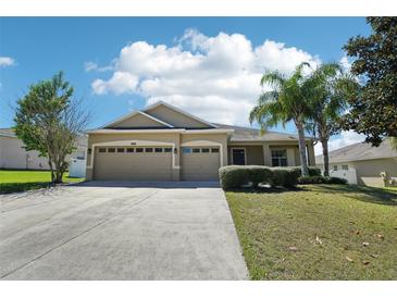 Charming single-story home features a three-car garage, manicured lawn, and mature landscaping at 5832 Tarleton Way, Mount Dora, FL 32757