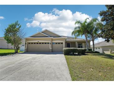 Charming one-story home with a manicured lawn and a three-car garage and mature trees at 5832 Tarleton Way, Mount Dora, FL 32757