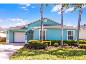 Charming, colorful single-story home with a well-manicured lawn and tropical landscaping at 631 Reserve Dr, Davenport, FL 33896