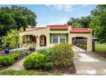 Charming home featuring a red tile roof, arched entry, and a lush, landscaped front yard at 809 Poinsettia Dr, Eustis, FL 32726