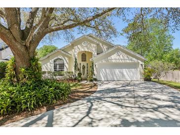 Charming home featuring a manicured lawn, mature trees, and a two-car garage at 1120 Parker Canal Ct, Oviedo, FL 32765