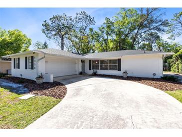 Charming single-story home with a large driveway and well-maintained landscaping in a lush, green setting at 1338 Franklin St, Altamonte Springs, FL 32701