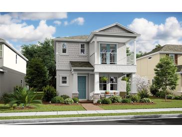 Charming two-story home featuring a balcony, manicured landscaping, and a welcoming front porch, creating an inviting curb appeal at 15573 Gentle Rain Dr # 193, Winter Garden, FL 34787