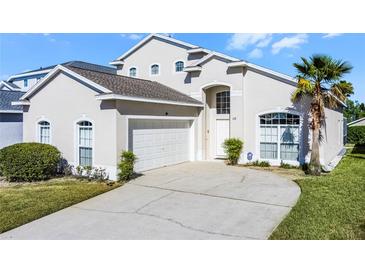 Charming two-story home featuring a well-manicured lawn and a driveway leading to a two-car garage at 218 Castlemain Cir, Davenport, FL 33897
