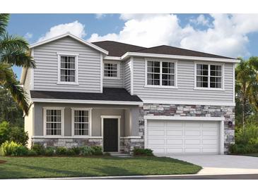 Inviting two-story home featuring stone accents, a covered entryway, and an attached two-car garage at 33432 Seattle Slew Dr, Sorrento, FL 32776