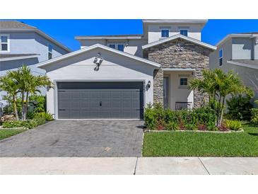 Charming two-story home with stone accents, manicured lawn, and paved driveway at 4630 Cragmere Loop, Clermont, FL 34711