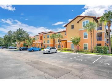 Beautiful two-story condo building featuring a parking lot and lush landscaping at 5471 Vineland Rd # 7108, Orlando, FL 32811