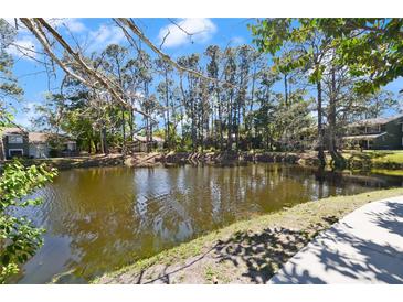 A scenic pond view surrounded by mature trees provides a relaxing atmosphere to this community at 6114 Peregrine Ave # D03, Orlando, FL 32819