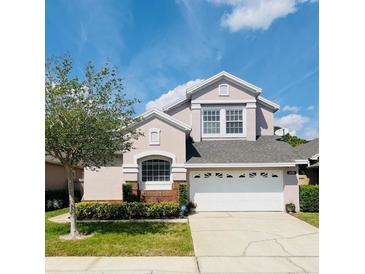 Charming two-story home featuring a well-manicured lawn, inviting curb appeal and a spacious two-car garage at 14339 Windchime Ln, Orlando, FL 32837