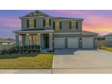 Two-story home featuring a three-car garage and a well-manicured lawn at 14418 Bayuk Way, Winter Garden, FL 34787