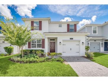 Charming two-story home with well-manicured lawn and an attached garage at 1555 Flange Dr, Davenport, FL 33896