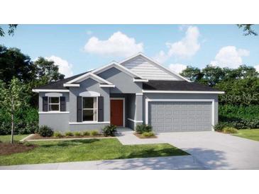 Charming single-story home featuring a two-car garage, neutral paint, dark shutters, and manicured landscaping at 6611 Lullaby Ln, Mascotte, FL 34753