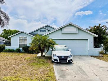 Charming single-Gathering home with a two-car garage, palm tree, and well-manicured front yard at 72 Saint Kitts Cir, Winter Haven, FL 33884