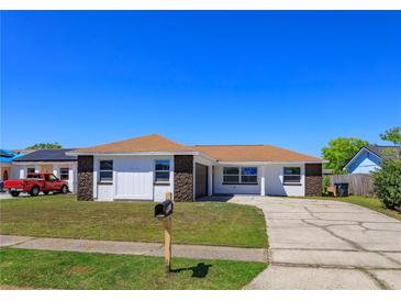 Charming single-story home featuring a well-manicured lawn and a long driveway, perfect for Gathering living at 7717 Boreas Dr, Orlando, FL 32822