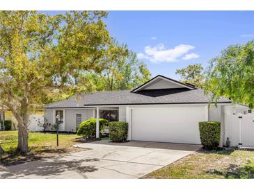 Charming one-story home with a well-manicured lawn, mature trees, and a two-car garage at 1259 Freeport Dr, Deltona, FL 32725