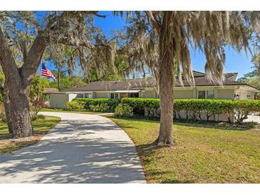 Charming one-story home with manicured landscaping, mature trees, and a long driveway leading to the entrance at 1285 Seminole Ave, Longwood, FL 32750