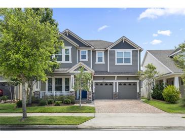 Beautiful two-story home with manicured lawn, brick driveway, and a welcoming covered front porch at 8433 Corkfield Ave, Orlando, FL 32832