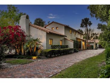 Charming home showcasing lush landscaping, a brick driveway, and a classic stucco exterior with a red tile roof at 851 Georgia Ave, Winter Park, FL 32789