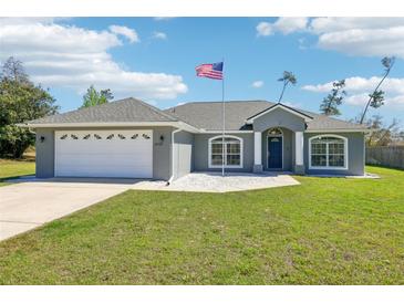 Charming single-story home with a well-manicured lawn and an American flag proudly displayed at 10367 Sw 45Th Ave, Ocala, FL 34476