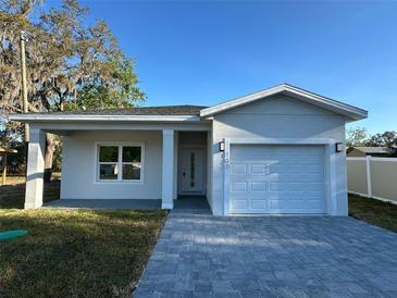 Charming single-story home featuring a one-car garage and a beautifully paved driveway and walkway at 137 W G H Washington St, Apopka, FL 32703