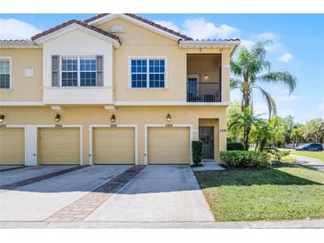 Inviting townhouse showcases a two-story elevation, four garage doors, and lush landscaping at 2898 Oakwater Dr # 2898, Kissimmee, FL 34747