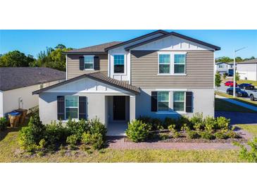 Charming two-story home featuring a landscaped yard, neutral color palette and inviting covered entryway at 5251 Meredrew Ln, St Cloud, FL 34771