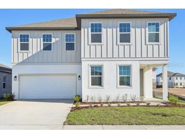 Charming two-story home with a well-manicured lawn and attached two-car garage at 5717 Haystack Dr, St Cloud, FL 34771