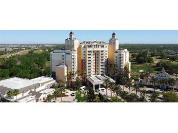 Stunning exterior view of a luxury hotel featuring towers, palm trees, and resort-style amenities at 7593 Gathering Dr # 203, Reunion, FL 34747