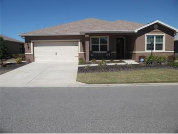 Charming single-story home with a well-manicured lawn, a two-car garage, and a welcoming front porch at 8824 Sw 104Th Cir, Ocala, FL 34481