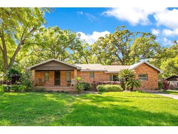 Charming single-story brick home with a well-manicured lawn and mature trees in a peaceful residential neighborhood at 1120 Sheeler Ave, Apopka, FL 32703