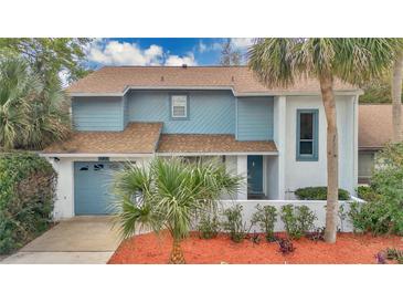 Inviting two-story home featuring a well-manicured front yard with lovely palm trees at 122 Spreading Oak Ct, Sanford, FL 32773
