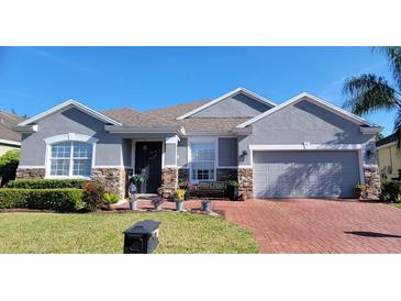 Charming single-story home with a brick driveway, stone accents, and a well-manicured front lawn at 1530 Lexington Av Ave, Davenport, FL 33837