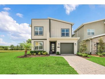 Modern two-story home boasts manicured lawn, complementing the facade, and inviting pathway at 2775 Bookmark Dr, Kissimmee, FL 34746