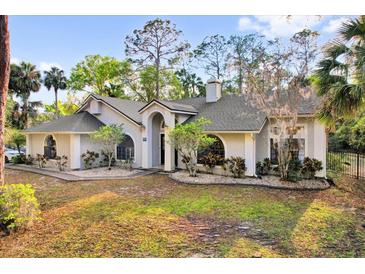 Charming single-story home boasting mature landscaping, a gray roof, and a welcoming front entrance at 322 Harbor Trl, Enterprise, FL 32725
