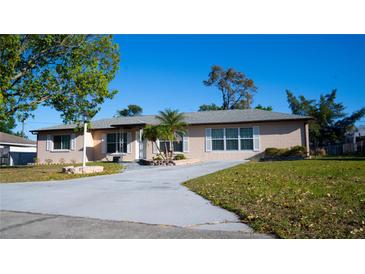 Charming home with a well-maintained lawn, inviting driveway, and beautiful landscaping at 345 W Seminole Ave, Eustis, FL 32726