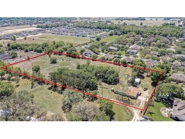Expansive aerial view of a property with a large lot, framed by mature trees and neighboring homes at 4550 Chandler Rd, Apopka, FL 32712