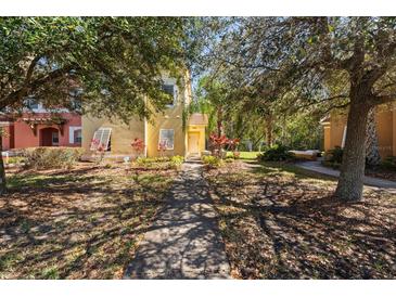 Inviting front yard and walkway lead to this charming yellow home with lush landscaping at 4772 Vero Beach Pl, Kissimmee, FL 34746