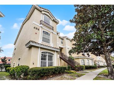 Three-story building exterior shows staircase, tiled roof, and beige stucco facade at 696 Seabrook Ct # 101, Altamonte Springs, FL 32714