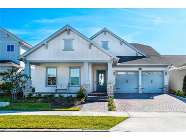 Inviting home with a beautiful exterior, complemented by a well-maintained lawn, brick pavers, and a charming porch at 13301 Mcmillan Dr, Orlando, FL 32827