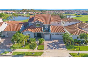 Stunning two-story home featuring a red tile roof, balcony, stone accents and a two-car garage at 13307 Alderley Dr, Orlando, FL 32832