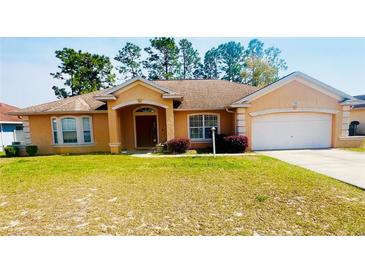 Charming single-story home featuring a well-maintained lawn and an attached two-car garage at 13405 Sw 86Th Ave, Ocala, FL 34473