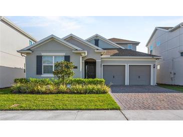 Charming single-Gathering home showcasing a well-manicured lawn, two-car garage and welcoming entrance at 19318 Banfield Pl, Orlando, FL 32827